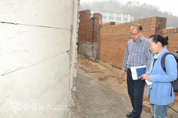 안선영 중구의원(우)이 관계자와 함께 균열이 발생한 담장을 살펴보고 있다.