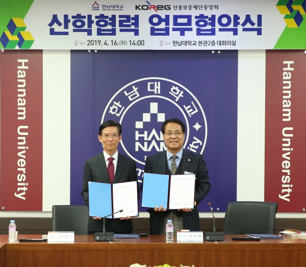 이덕훈 한남대 총장과 김병근 신용보증재단중앙회장이 산학협력을 체결하고 협약서 교환
