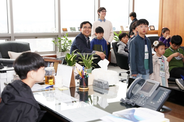 직원가족 초청 직장문화 체험행사에 참석한 직원 자녀가 부이사장실 집무실 책상에 앉아 장래희망을 말하고 있는 모습을 전만경 부이사장(왼쪽 2번째)이 경청하고 있다.