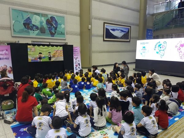 시청 로비에서 아이들이 어린이 인형극 ‘동생이 필요해요’와 동화구연 ‘나도 동생이 있었으면 좋겠어요’를 관람하고 있다.