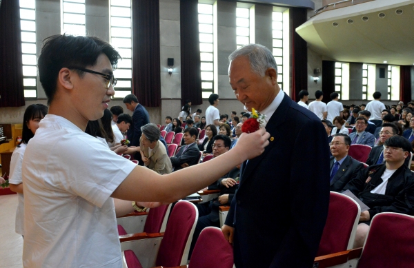 백석대 송대선 총학생회장이 장택현 대학혁신위원장에게 카네이션을 달아주고 있다