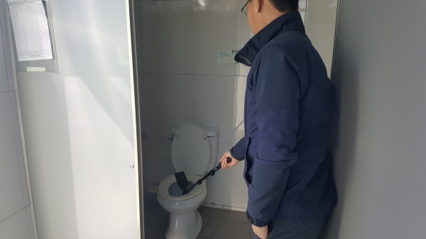 동구청 직원이 탐지기를 통해 공중화장실 몰래카메라 설치 유무를 점검하고 있다