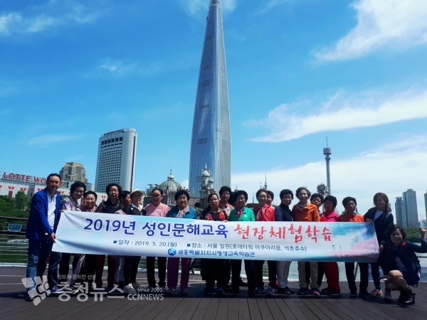 수강생들이 석촌호수에서 롯데타워를 배경으로 단체촬영을 하고 있다.