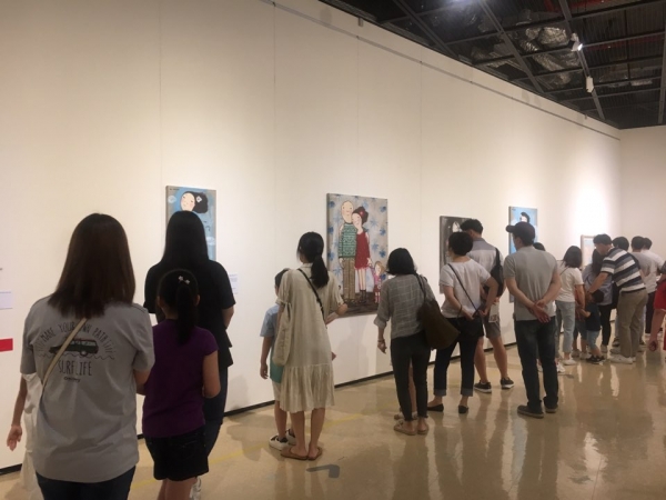 '행복을 그리는 화가 에바 알머슨' 전시회를 관람하고 있는 시민들 모습