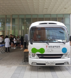 학생들이 결핵검진을 받기 위해 검진 차량 앞에서 대기하고 있는 모습