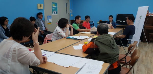 자원봉사자가 장애인들에게 책을 읽어주는 모습