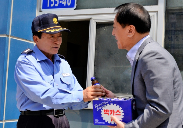 김선재(오른쪽) 배재대학교 총장이 17일 대학 발전기금을 쾌척한 경비원 조동주 씨에게 음료를 전달하고 있다