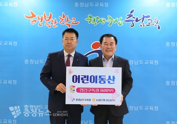 NH농협은행 충남영업본부 조두식 본부장이 김지철 충남교육감에게 어린이동산 연간구독권을 기증하고 있다.