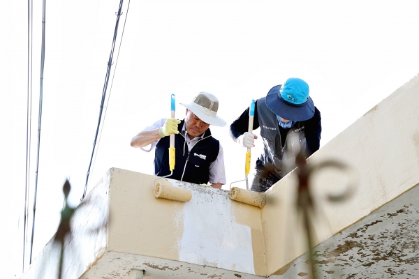 김인식 농어촌공사 사장이 성당 포구마을에서 농촌재능나눔 참석자들과 집고쳐주기 봉사활동으로 외벽 페이트칠을 하고 있다.