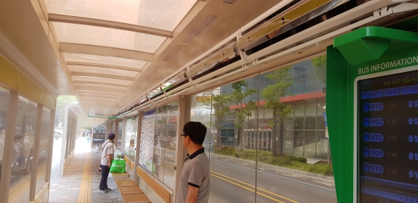 시민들이 모종 시내버스 환승센터에서 물안개 냉방장치로 무더위를 피해 시내버스를 기다리고 있다.