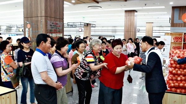 김인식 사장이 판촉용 양파를 지역주민에게 직접 나눠주며 양파마늘 농가돕기 동참을 권유했다