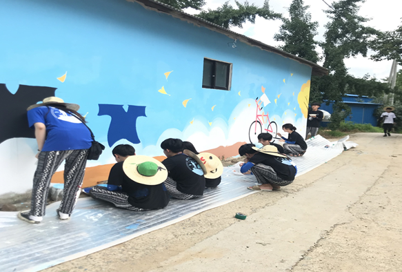 ‘한밭 품들이봉사단’ 학생들이 충남 보령시 청라면 은행마을에서 벽화를 그리고 있다