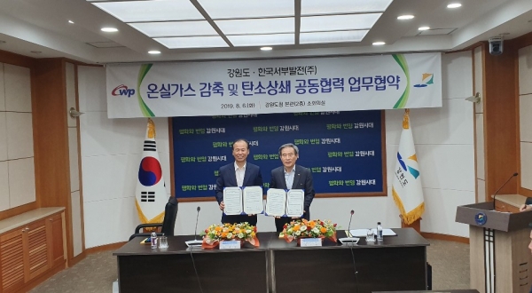 한국서부발전 김병숙 사장(우)과 강원도 최문순 도지사(좌)가 「온실가스 감축 및 탄소상쇄 공동협력 업무협약」을 체결하고 기념촬영