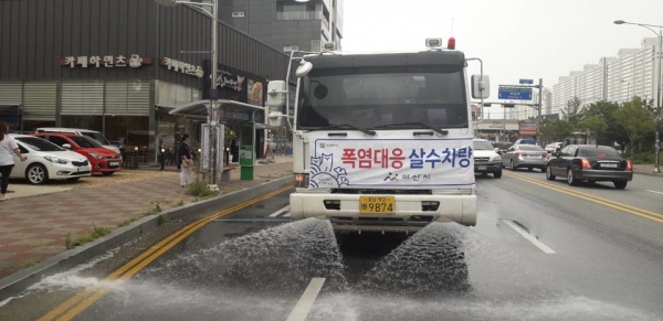 도로살수차가 도로의 열기를 식히기 위해 작업하고 있는 사진