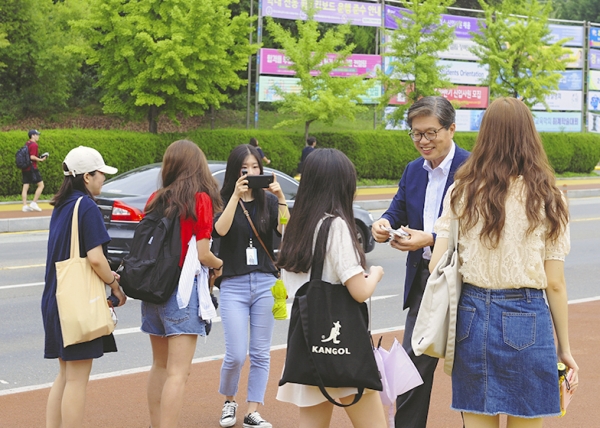 개강 환영 이벤트를 진행 중인 오덕성 총장이 학생들에게 쿠키를 나눠주고 있다.