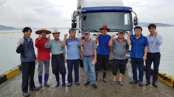 충남 태안군 만대 일대에서 한국서부발전과 서산 수협, 만대어촌계장 등 관계자들이 치어를 방류한 후 기념촬영을 하고 있다.