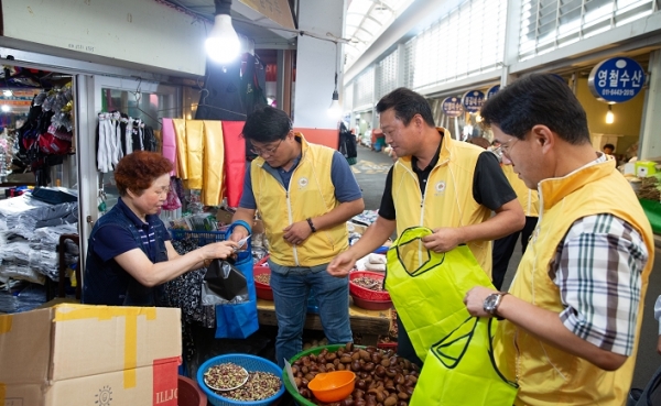 한국서부발전 유승재 노조위원장(왼쪽 2번째)이 전통시장에서 물품을 구매하고 있다.