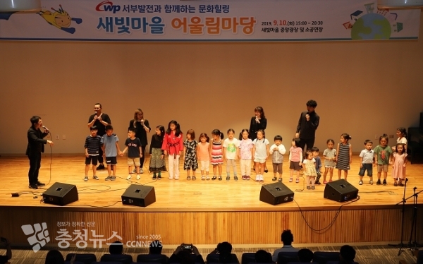 한국서부발전 사택 내 소공연장에서 이루어진 아카펠라 그룹의 공연에 지역주민들의 자녀들이 참여하고 있는 모습