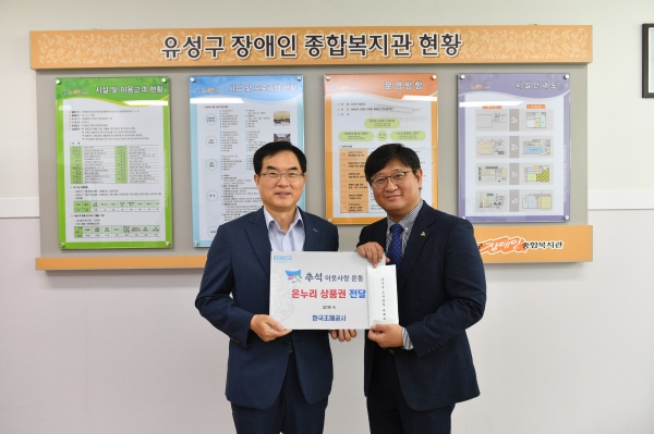 조용만 사장(사진 왼쪽)이 김영근 대전 유성구장애인복지관장에게 온누리상품권을 전달하고 있다