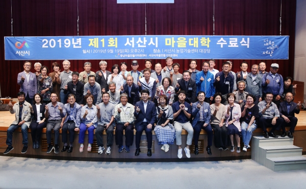 ‘제1회 마을대학 수료식’에서 맹정호 서산시장(가운데)과 마을대학 관계자들이 단체사진을 찍고 있다.