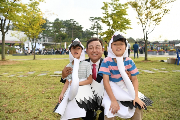 황선봉 군수가 황새 복장을 한 어린이들과 기념촬영을 하는 모습