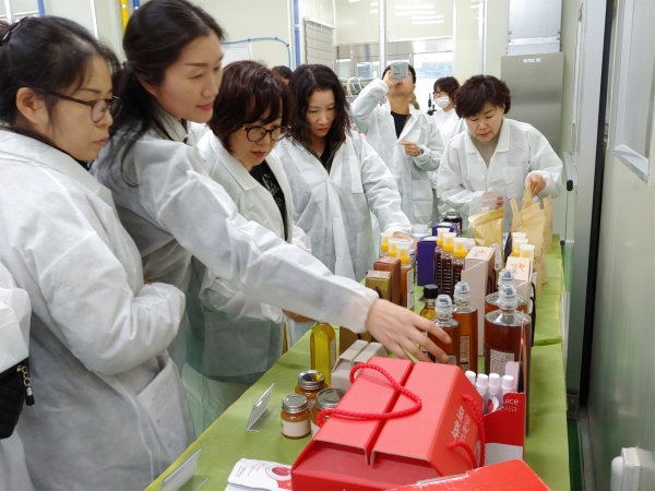 예산군 영양사들이 친환경 농작물 생산현장을 방문해 가공품을 살펴보는 모습