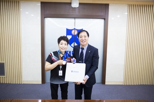 배재대 김선재 총장(오른쪽)이 이미령 매니저(왼쪽)에게 축하를 전하고 있다