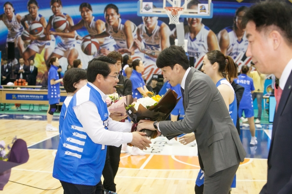 홈 개막전을 축하하는 꽃다발을 위성우 감독에게 전하는 오세현 아산시장