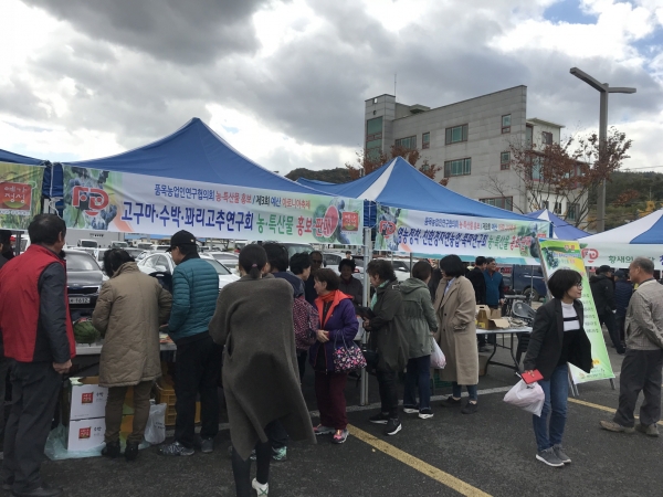 지난해 품목농업인연구회원들이 농·특산물을 전시한 가운데 참가자들이 시식을 하는 모습