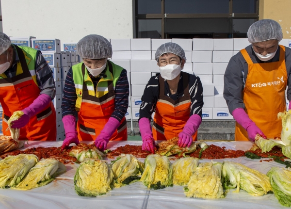 박정현 대덕구청장이 구청 청렴관 앞에서 열린 사랑의 김장 나눔 행사에서 자원봉사자들과 함께 김장 김치 속을 넣고 있다.