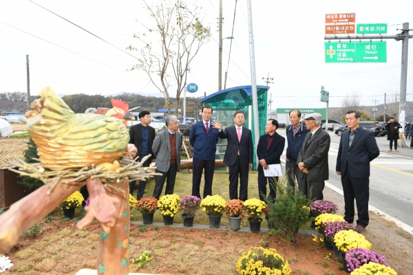 황선봉 군수(사진 가운데)와 이경진 예산군행복마을지원센터장(왼쪽에서 두번째), 홍문표 국회의원(왼쪽에서 세번째) 등 관계자들이 황계리 황금정원을 살펴보는 모습.