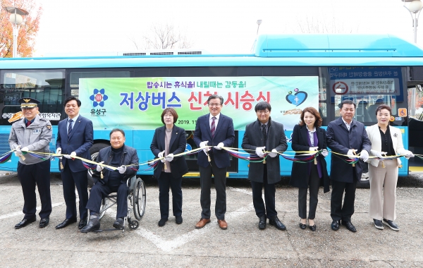 18일 유성구장애인종합복지관에서 열린 장애인 저상버스 시승식에서 정용래 유성구청장(가운데), 이상민 국회의원(왼쪽 세 번째), 조승래 국회의원(왼쪽 두 번째), 하경옥 의장(왼쪽 네 번째)과 주요 내빈들이 테이프 커팅을 하고있다.