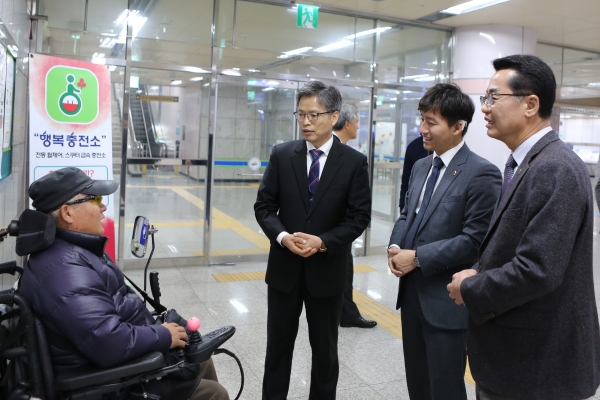 전동휠체어 무료충전기를 이용하고 고객과 대화를 나누고 있는 김경철사장, 우승호의원, 최재천협회장.