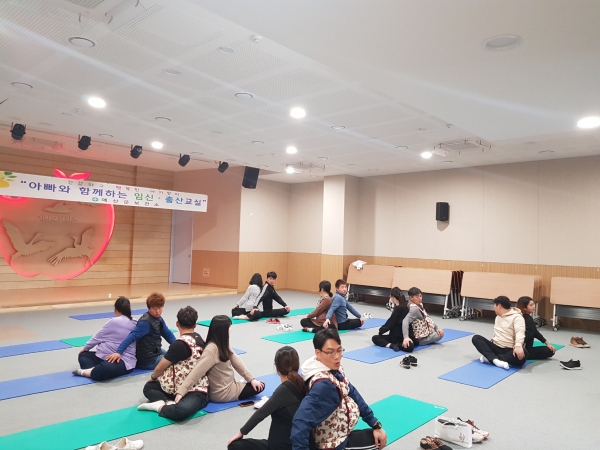 아빠와 함께하는 임신·출산교실 참가자들이 요가를 하는 모습