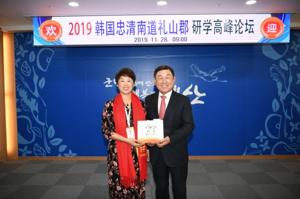 황선봉 군수(오른쪽)가 중국 북경 교육관계자 교류단에게 기념품을 전달하는 모습.