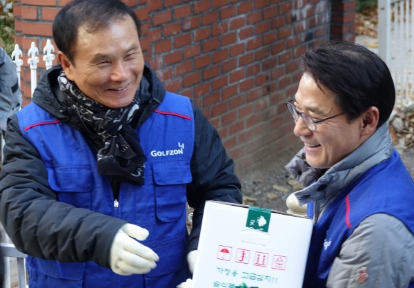 지난 29일(금) (좌측부터) 골프존뉴딘그룹 김영찬 회장과 골프존뉴딘홀딩스 최덕형 대표이사가 연말 그룹봉사활동에 동참해 지역사회 취약계층 가정에 전달할 김치를 운반하고 있다