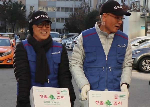 (좌측부터) 골프존 박기원 대표이사와 골프존 문제해 전무가 지난 29일(금) 진행된 2019 사랑의 지역사회 봉사활동에 동참해 강남구 소외된 이웃들에게 전달할 김치를 옮기고 있다.