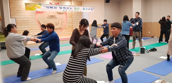 아빠와 함께하는 임신·출산교실 참가자들이 요가를 하는 모습