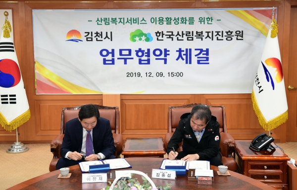 이창재(좌측) 한국산림복지진흥원장이 9일 경북 김천시 김천시청에서 김충섭 김천시장과 업무협약서에 서명을 하고 있다.