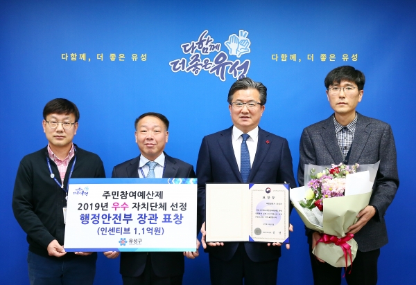 지난 13일 구청 행복사랑방에서 정용래 유성구청장(오른쪽에서 두 번째)이 전상배 마을자치과장(왼쪽에서 두 번째)과 박희동 자치분권팀장(맨 오른쪽), 허정현 주무관(맨 왼쪽)과 함께 표창장을 들고 기념촬영