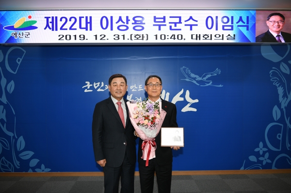 황선봉 군수가 이상용 부군수(오른쪽)에게 패를 전달하고 기념촬영하는 모습