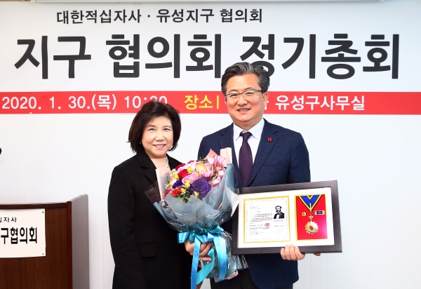 30일 오전 유성커뮤니티센터에서 정용래 유성구청장(오른쪽)이 대전세종지사 한광숙 부회장(왼쪽)으로부터 적십자 회원유공장 명예장을 수여받고 있다.