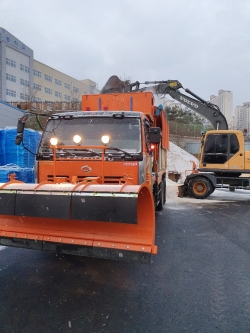 제설차에 염화칼슘을 분주히 싣고 있다.