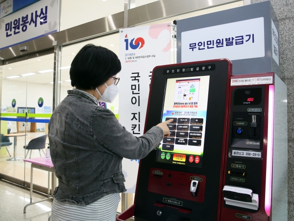 서구청 1층에 설치된 무인민원발급기에서 한 주민이 증명서를 발급하고 있다