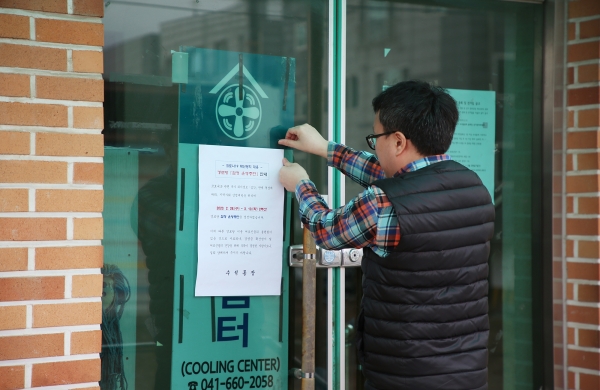 서산시 직원들이 경로당 폐쇄 안내문을 부착하고 있다.
