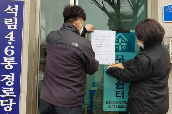 서산시 직원들이 경로당 폐쇄 안내문을 부착하고 있다.