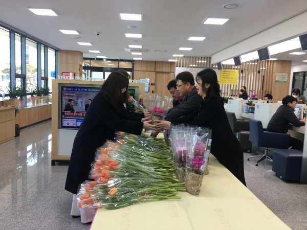 충남 관내 영업점 객장에서 꽃나눔 행사를 하는 모습