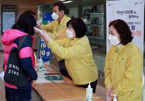 아산시의회 김영애의장, 현인배, 조미경의원이 체열측정기를 이용해 출입자들에 대한 발열검사와 손 소독을 실시하고 있다.