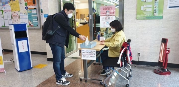 지난 6일 관평동 행정복지센터를 방문한 민원인이 입구에 비치돼 있는 손소독제를 사용하고 있다.