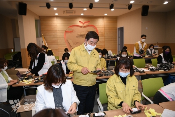 황선봉 군수가 스티커 작업중인 면 마스크를 살펴보는 모습